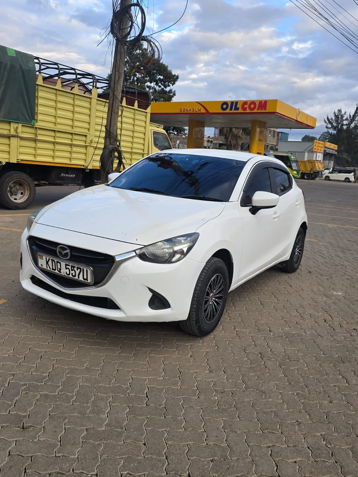 White Mazda Demio KDQ 557U — front three-quarter view