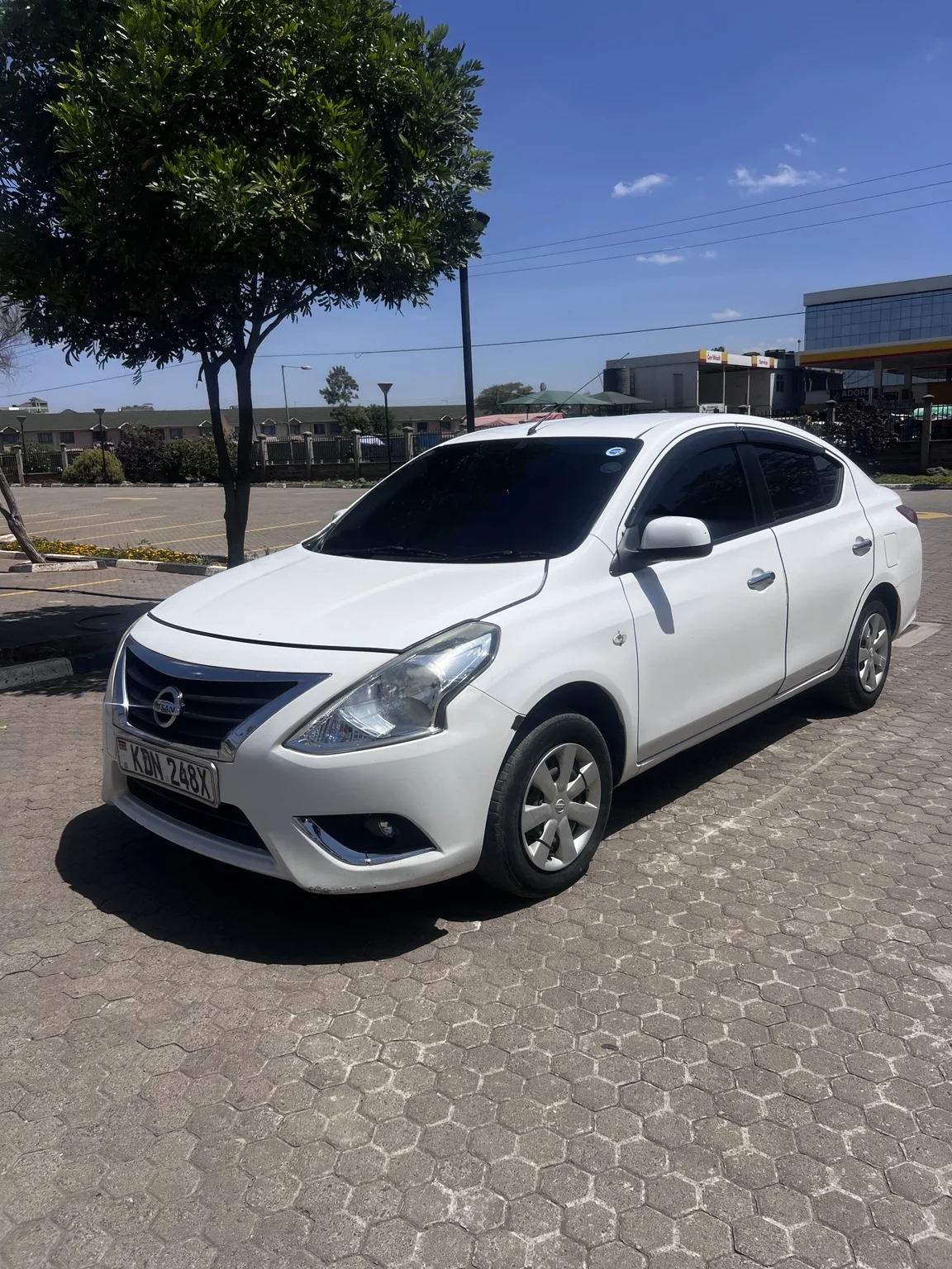2015 white Nissan Latio KDN 248X — front three-quarter view